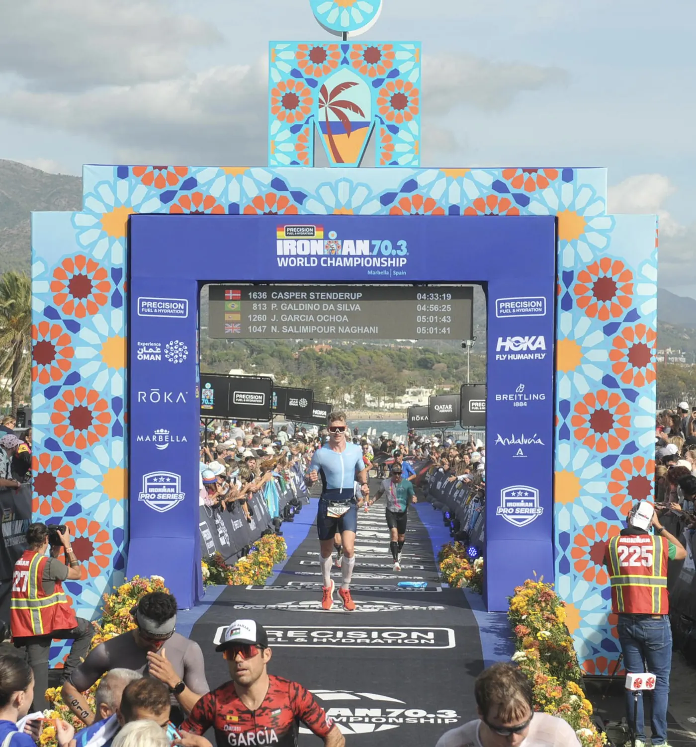 John Fagan running through the finish arch at the IRONMAN 70.3 World Championship in Marbella